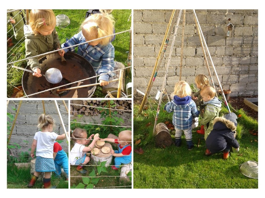 Vier peuters spelen buiten in een tuin met houten stokken, takken en ander speelmateriaal.