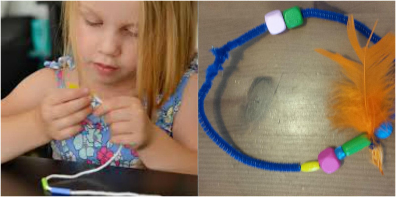 Een meisje maakt een armband met kleurrijke kralen en een veer op een tafel.