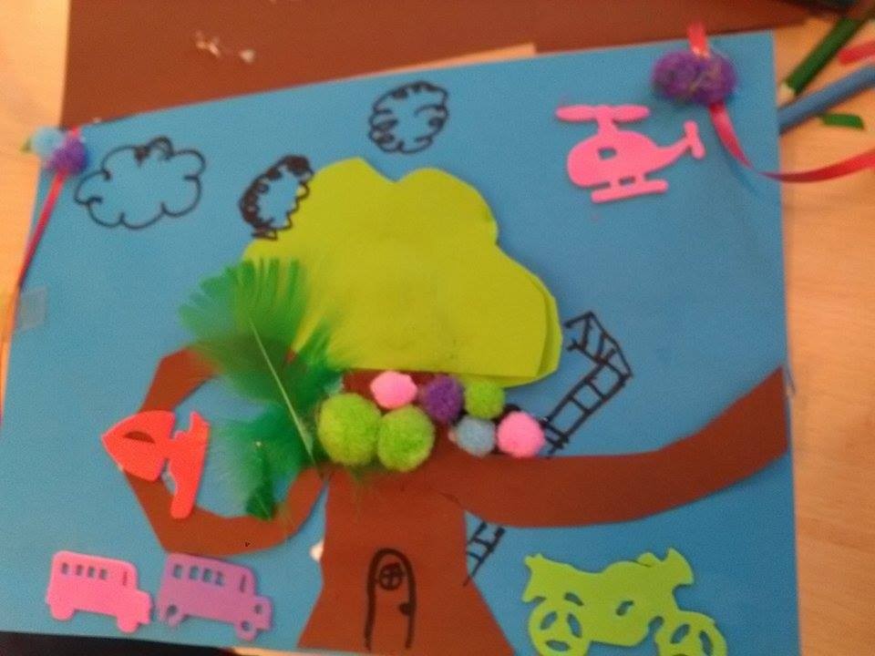 Een kleurrijke tekening met een boom, wolken, voertuigen en een helikopter op een blauwe achtergrond.