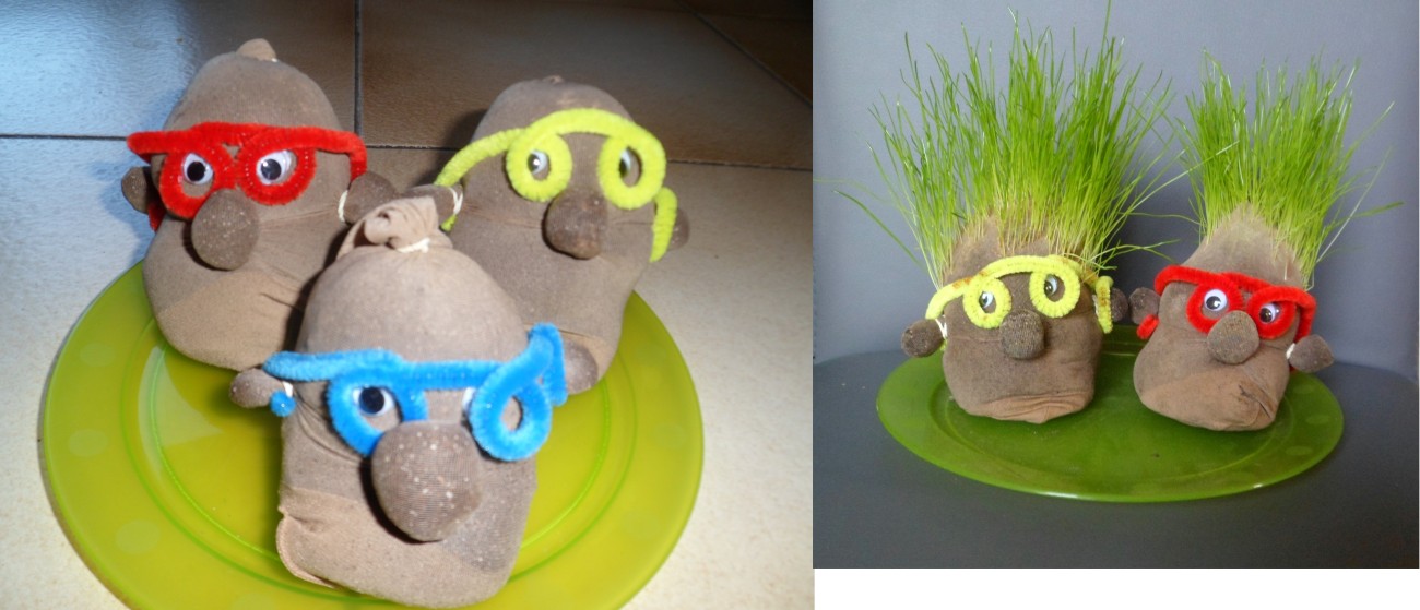 Drie stenen figuren met gekleurde brillen op een groen bord, en twee figuren met gras als haar op een andere schotel.